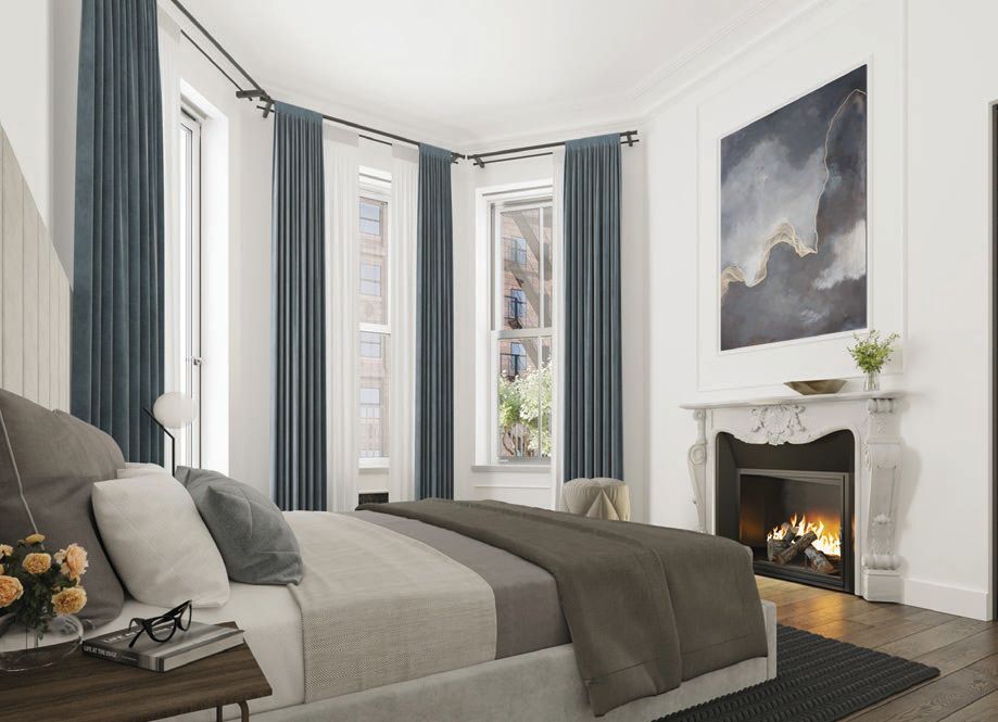 a fireplace makes the primary bed a cozy escape PHOTO COURTESY OF BRAND